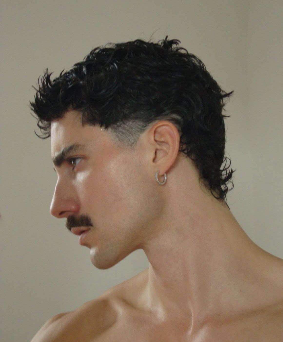 Slicked back modern mullet hairstyle for men